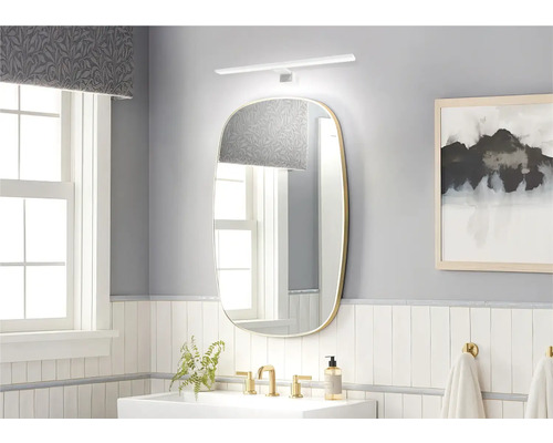 Ljust badrum med spegel, tvättställ och armaturer