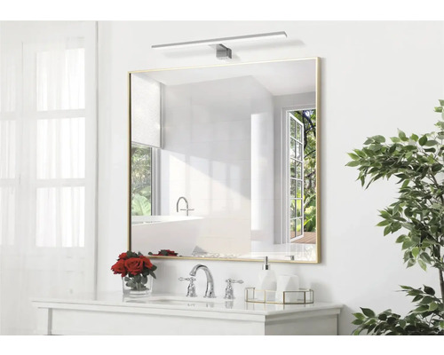 Fyrkantig spegel med belysning ovanför handfatet i badrummet.