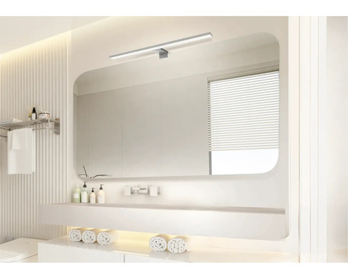 Ljust badrum med spegel, handfat och handdukar