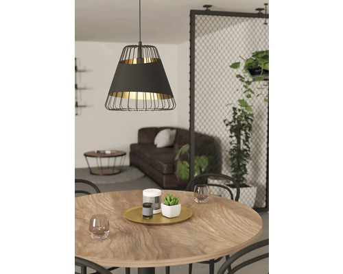 Matsal med träbord och svart hänglampa