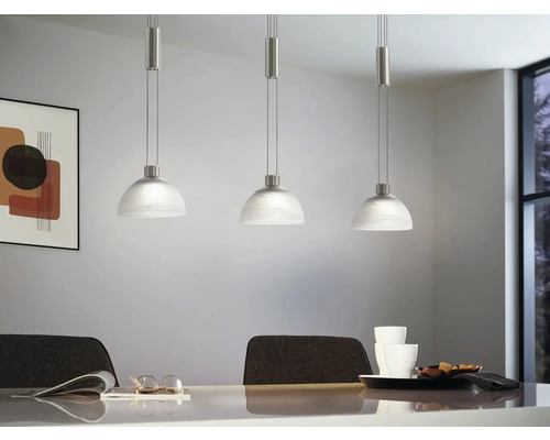 Tre glas taklampor ovanför ett matbord