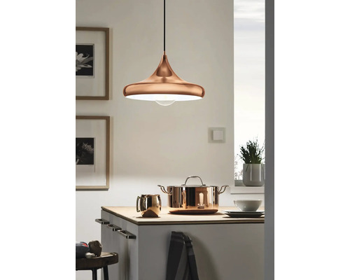 Metallhänglampa ovanför en köksbänk med kastrull och mugg