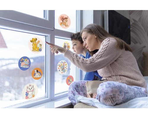 Mamma och barn tittar på fönsterdekaler med djurmotiv på en fönsterruta