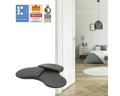 Dörrstopp på golvet framför en öppen dörr med ett sovrum i bakgrunden