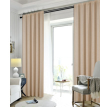 Vardagsrum med gardiner, fåtölj och sidobord