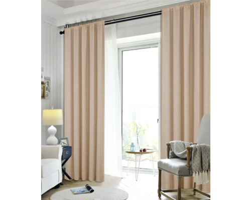 Vardagsrum med gardiner, fåtölj och sidobord