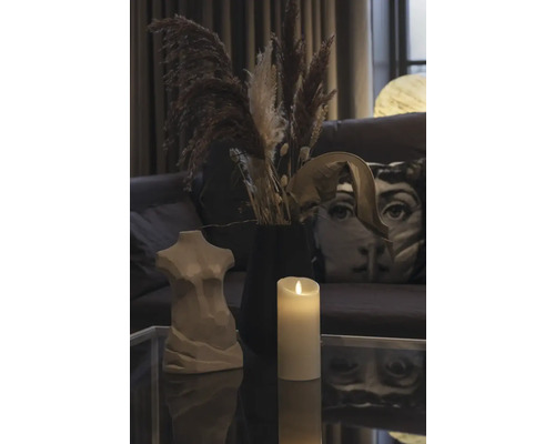 Dekoration med kvinnobyst, ljus och torkade blommor på ett bord