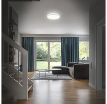 Vardagsrum med taklampa, soffa och fönster