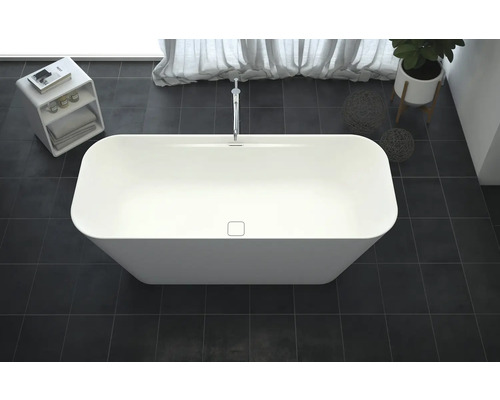 Fristående badkar i badrum med armatur, växt och förvaringshylla