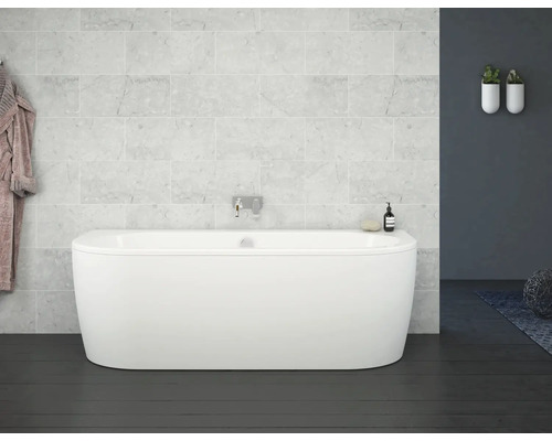 Fristående badkar i ett badrum med ljusa marmorplattor