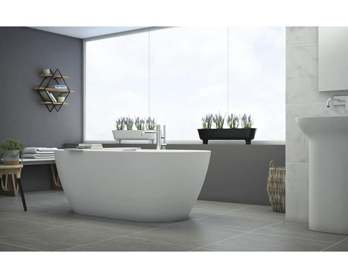 Ljust badrum med fristående badkar, handfat och dekoration