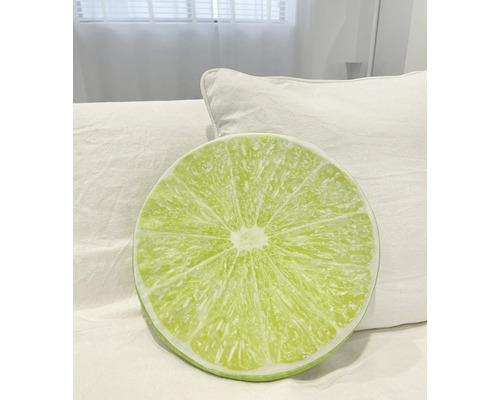 Rund kudde med lime-mönster på en säng