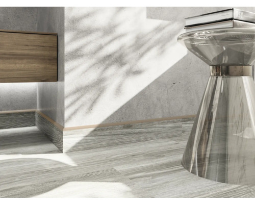 Detaljbild av en interiör med ett träelement, ett transparent bord och en bok