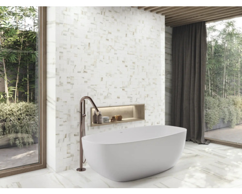 Modernt badrum med fristående badkar, mosaikvägg och fönster med utsikt över trädgården