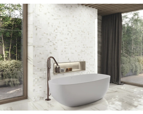 Badrum med fristående badkar, mosaikvägg och fönsterparti