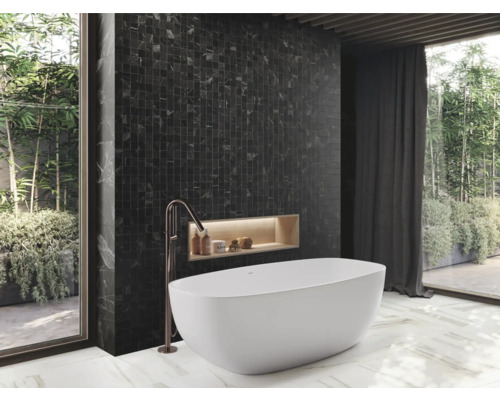 Badrum med badkar, mörk mosaik och fönsterparti