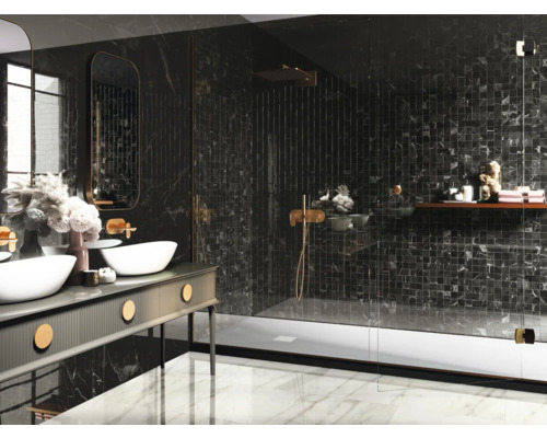 Badrum med tvättställ, spegel och dusch med mörka mosaikplattor.