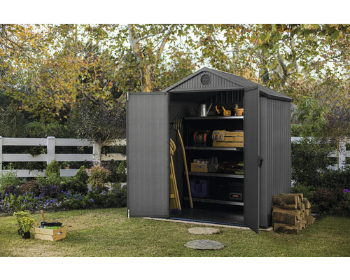 Trädgårdsscen med öppen redskapsbod med hyllor och trädgårdsredskap