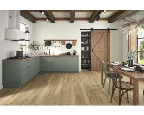 Ljust och rymligt kök med gröna skåp, trägolv och träbord