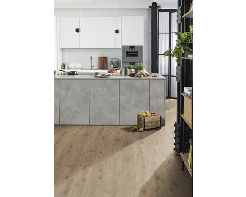 Ljust kök med köksö, vita skåp och trägolv.