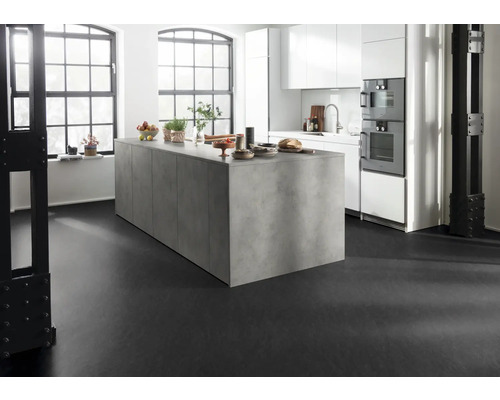 Ljust kök med köksö, vita skåp och svart golv.