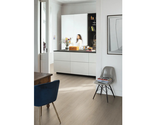 Ljust rum med köksö, stolar och golvbeläggning