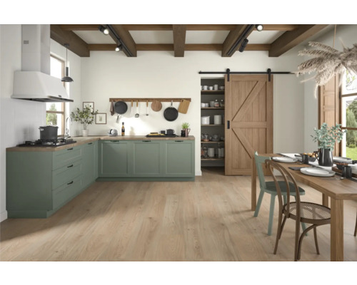 Ljust kök med hörnköksenhet, träbjälkar i taket och trädörrar