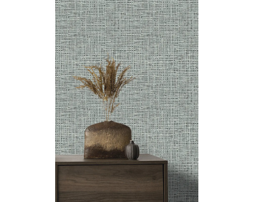 Närbild av en vägg med textilväggbeklädnad, en skänk och vaser.