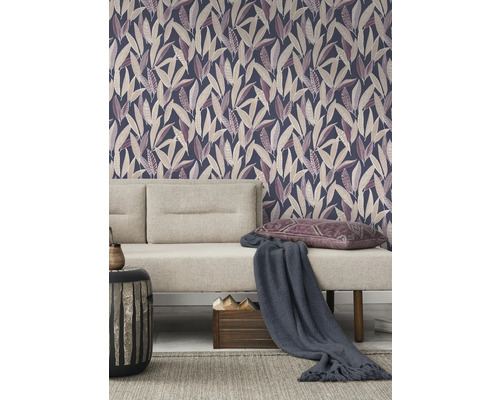 Vardagsrum med mönstrad tapet, soffa, kuddar och sidobord