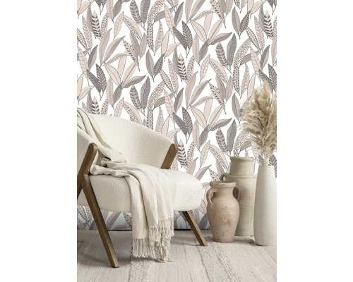 Dekorativt rum med fåtölj, filt, tapet med bladmönster och vaser.