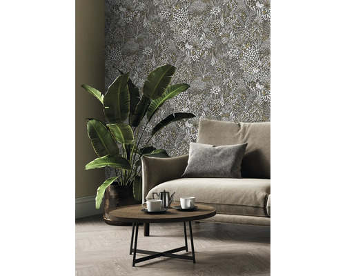 Vardagsrum med soffa, bord, krukväxt och mönstrad tapet