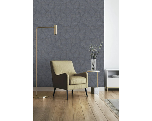 Vardagsrum med fåtölj, golvlampa och mönstrad tapet