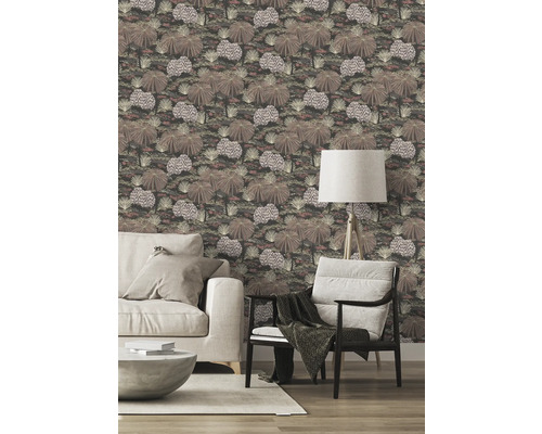 Vardagsrum med mönstrad tapet, soffa, fåtölj och golvlampa.