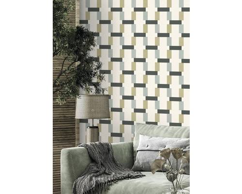 Vardagsrum med mönstrad tapet, soffa och lampa.