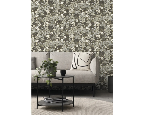 Vardagsrum med grå soffa, sidobord och tapet med blomstermönster