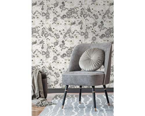 Scen med en stol, en matta och en blommig tapet för väggdekoration.