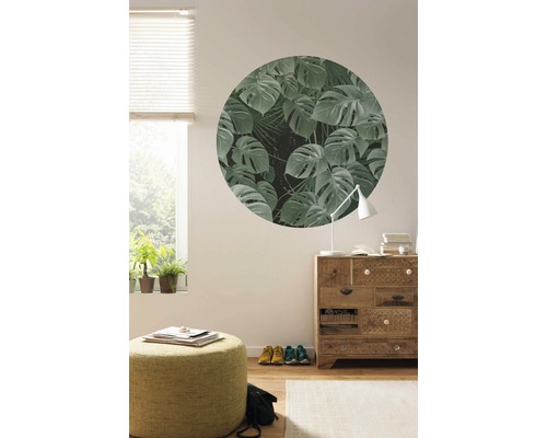 Vardagsrum med fönster, byrå, pall och cirkelformad väggmålning med växtmotiv