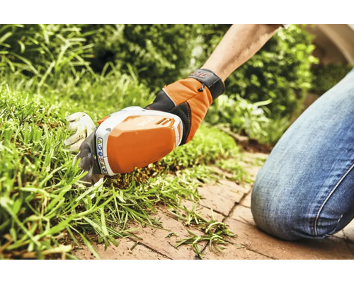 Batteridriven grässax som används för att trimma gräsmattor.