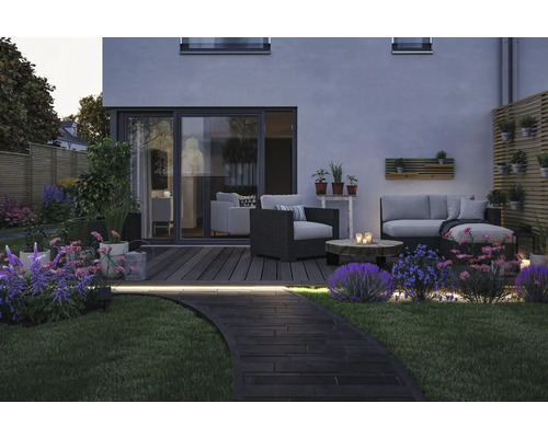 Trädgård med trädgårdsmöbler, uteplats, blommor och gångväg