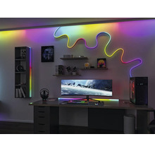 Modernt spelrum med skrivbord, datorskärm, hyllor och LED-belysning för en ljus och organiserad atmosfär