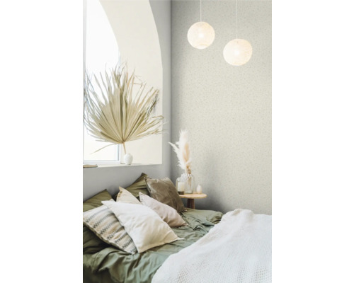 Sovrum med säng, kuddar, sidobord och dekorativa föremål