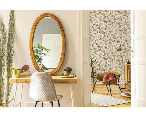 Ljus interiör med oval spegel, skrivbord och blommig tapet