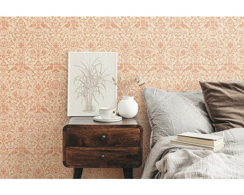 Sovrum med mönstrad tapet, sängbord och säng