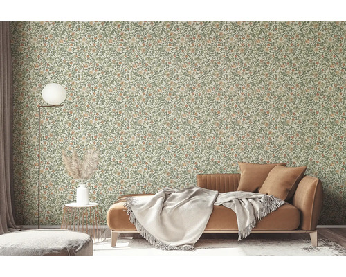 Vardagsrum med blommig tapet, soffa och golvlampa.