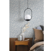 Sovrum med tapet med bladmönster, sängbord och lampa