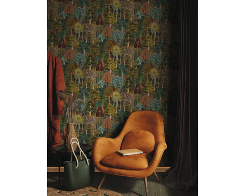 Inredningsidé med tapet med skogsmotiv, fåtölj, väska och dekorativa föremål för en mysig atmosfär