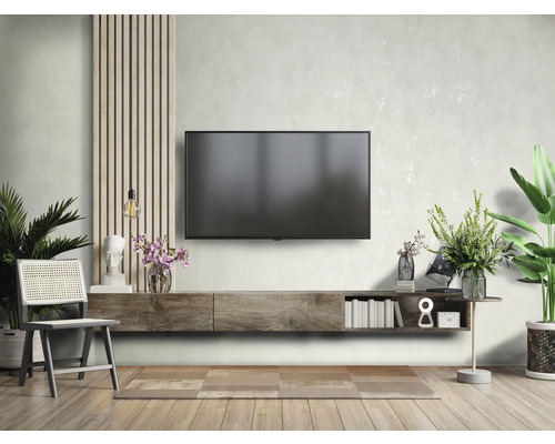 Vardagsrum med TV, låg skänk, stol och dekorationer för en stilfull inredning.