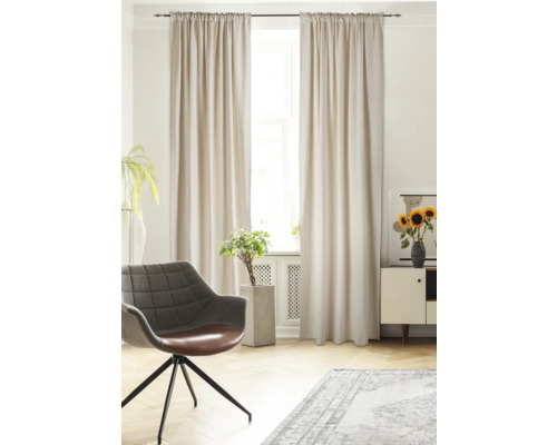 Ljust vardagsrum med gardiner, fåtölj, matta och dekoration