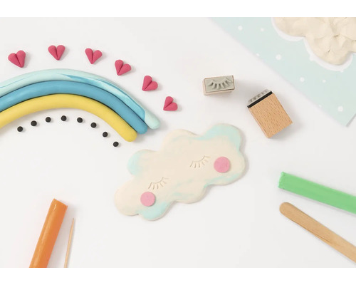 Scen med modellera som föreställer en regnbåge, moln, hjärtan och verktyg som används för att skapa figurer av modellera