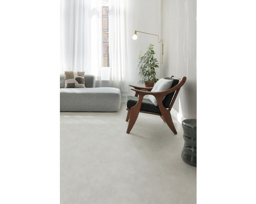 Ljust vardagsrum med soffa, fåtölj, golvlampa och krukväxt